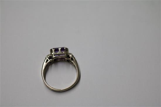 An 18ct white gold and emerald cut amethyst ring with diamond set shoulders, size P.